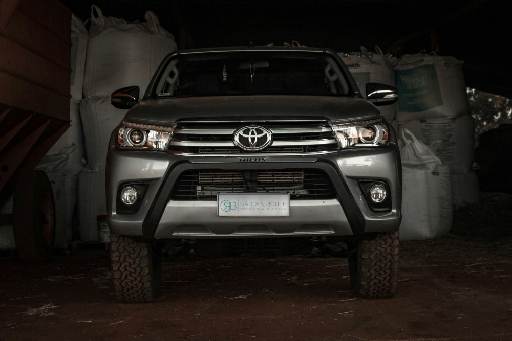 A Toyota Ford Hilux in a farmer's garage, with bags of seed behind it. This is one of the most targeted bakkies in car theft in South Africa
